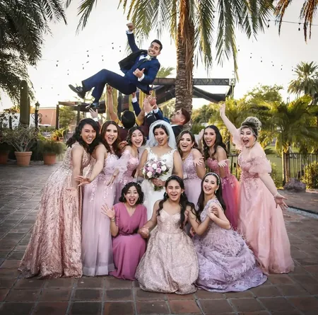 Wedding photo: bridal party pink dresses groom tossed