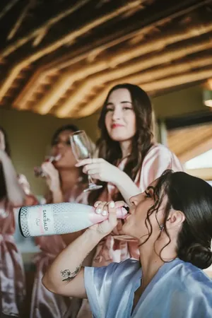 Wedding photo: bridesmaids drinking champagne from bottle