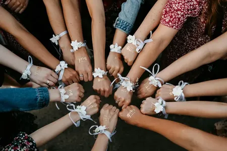 Wedding photo: bridesmaids wrists flower corsages circle
