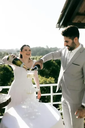 Wedding photo: couple pouring champagne tower balcony