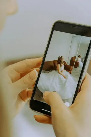 Wedding photo: phone photographing bride in mirror