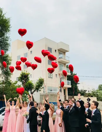 Wedding photo: wedding party releasing heart balloons